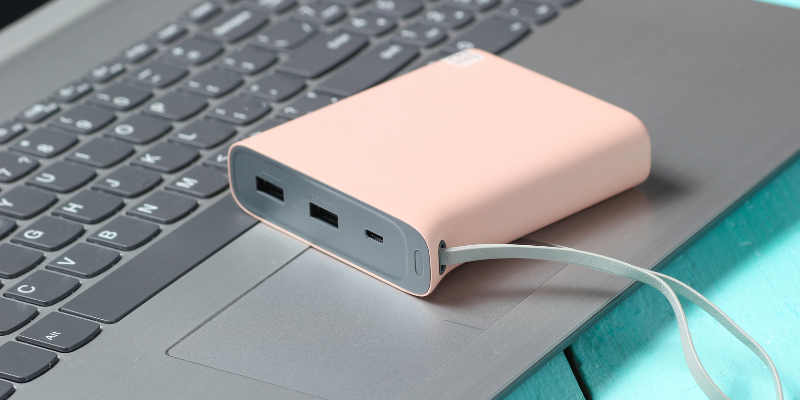 Pink portable charger sitting on top of an open laptop