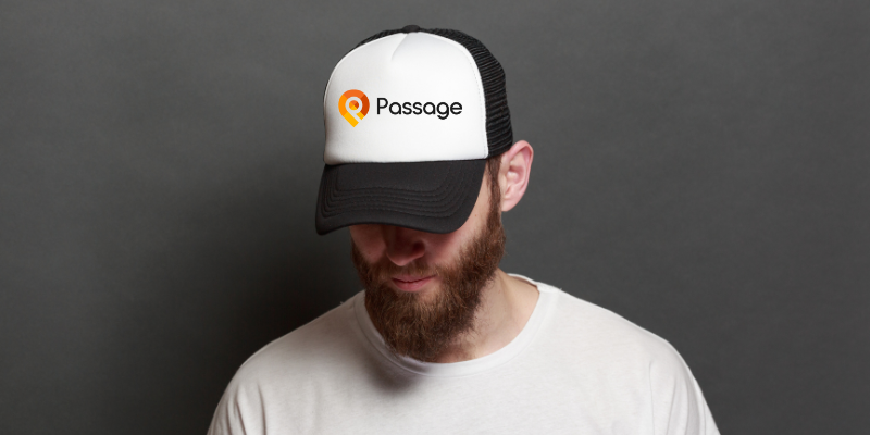 Man wearing a black and white baseball cap with the "Passage" logo on it.