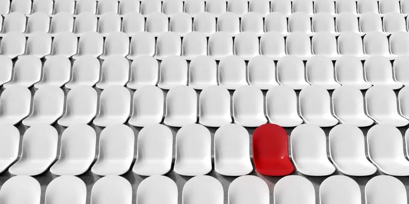 stadium seating with one red chair and the rest white