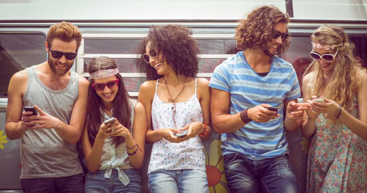 Friends using their phones to share events on social media