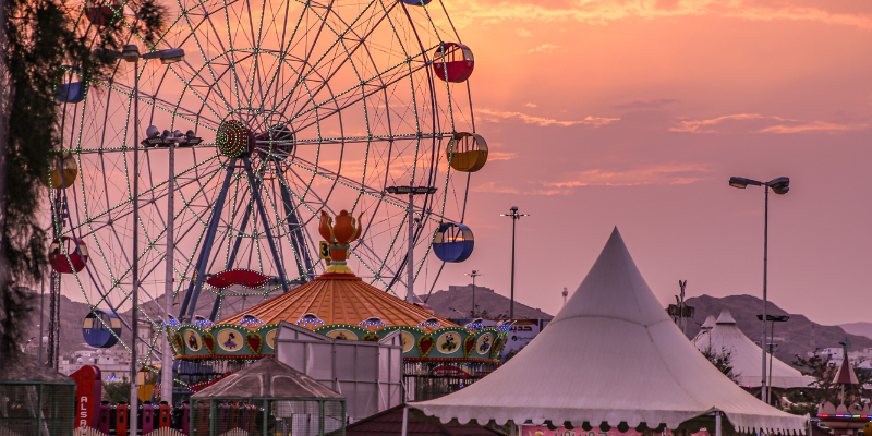 Sunset at an amusement park, overlooking a ferris wheel