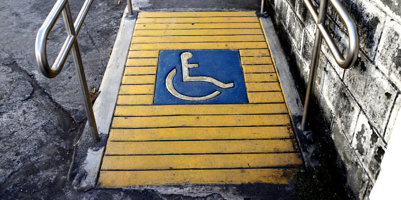 Wheelchair ramp with wheelchair symbol on it.