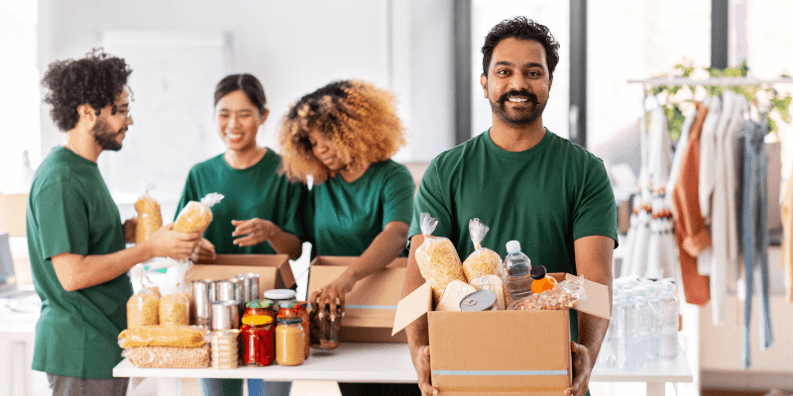 Four people packing up boxes of food to be donated.