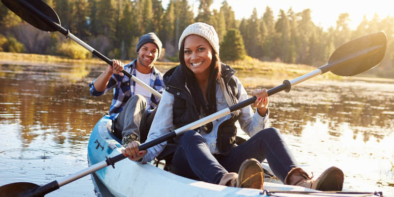 Happy couple rowing kayak on a lake