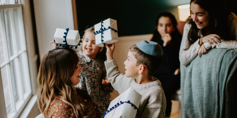 Family with children exchanging Hanukkah gifts