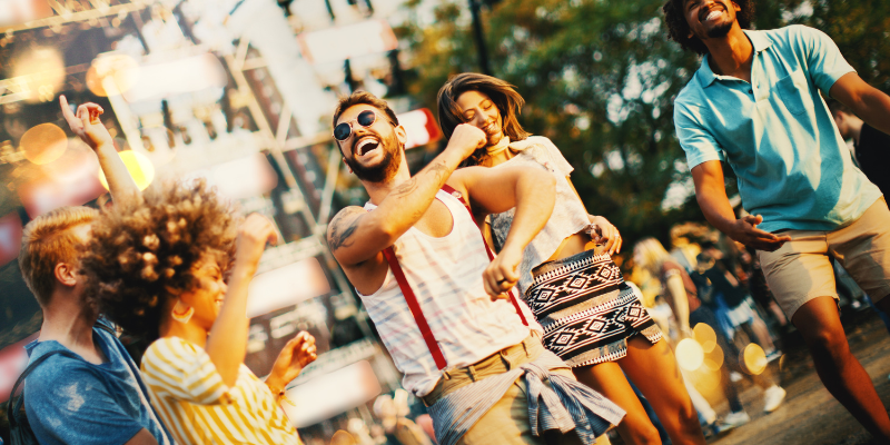 Friends dancing and jumping at music festival