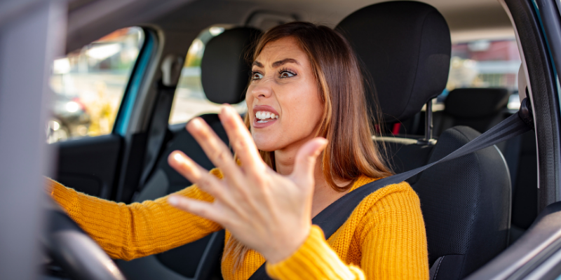 Angry woman driving a car honking the horn