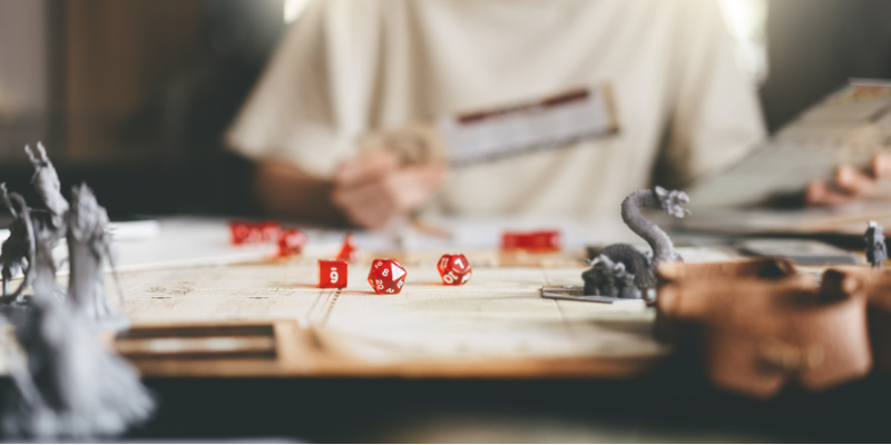 Role playing tabletop game with multi-sided dice and silver game pieces