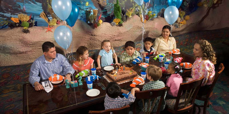 Family celebrating kids birthday party at a public aquarium