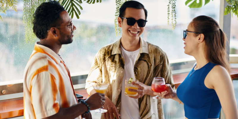 Happy party guests drinking cocktails and talking