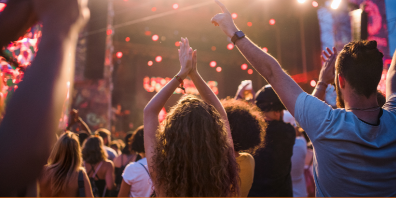 Rear view of a group of unrecognizable young people enjoying a concert
