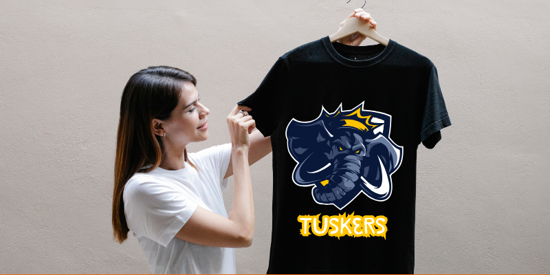 Smiling woman showing a black T-shirt on a hanger