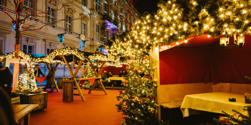 Festive Christmas market with lights and booth seating outdoors