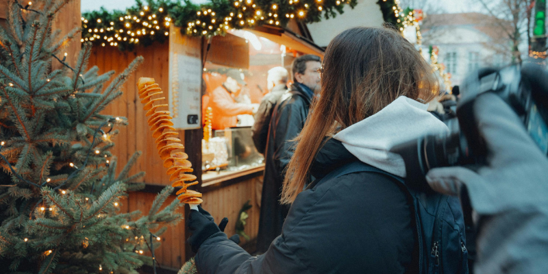 Winter market scene with a women holding a potato spiral on a stick