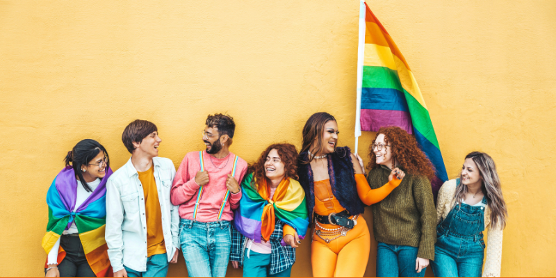 Diverse group of young people celebrating Pride festival against a yellow background