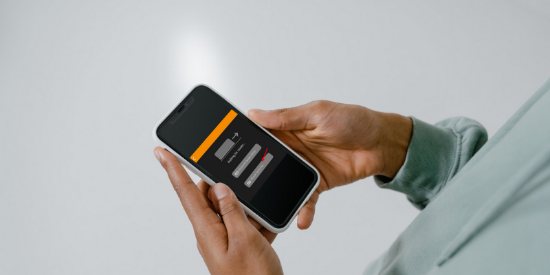 Close-up image of a persons hands holding mobile phone displaying Passage tap-to-pay connection screen