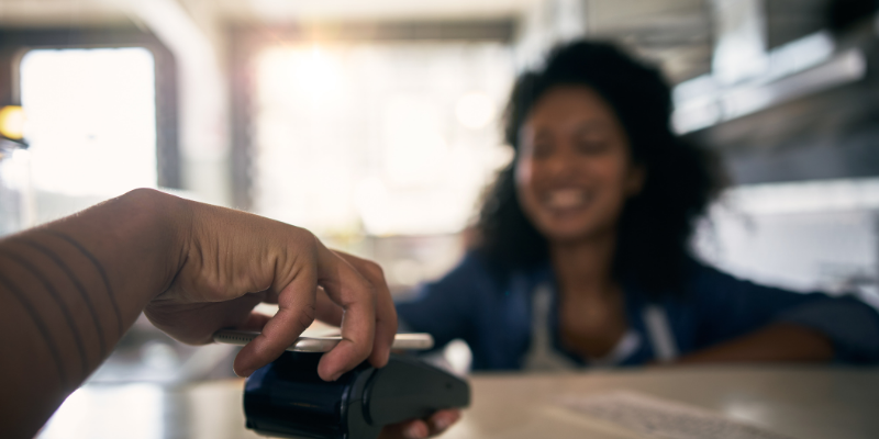 Cropped shot of an unrecognizable male customer making a contactless payment to a female coffee shop employee