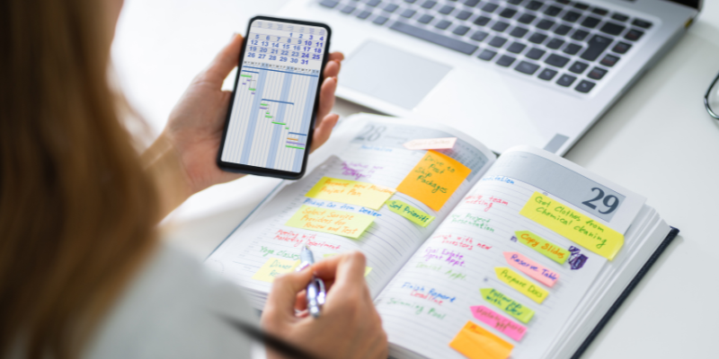 The Over-Planner persons hands with mobile phone and day planner