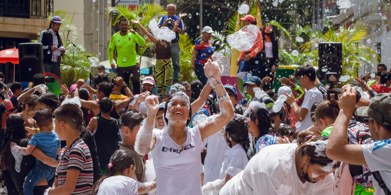 People dancing in bubbles in front of a stage while musicians play