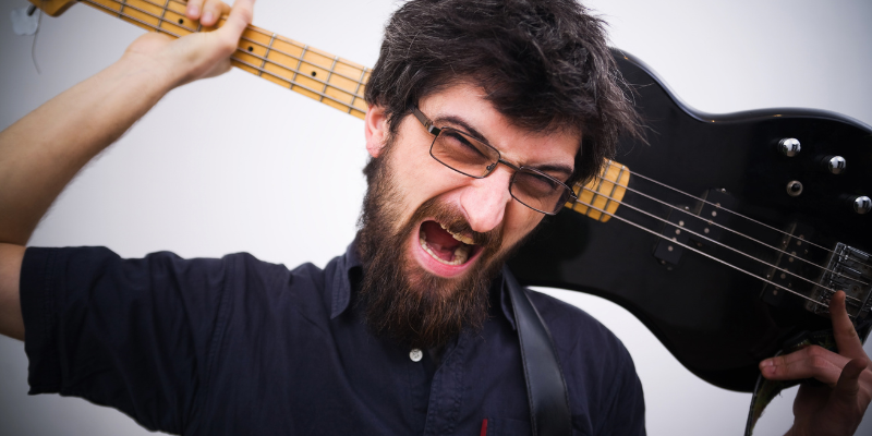 Rocker smashing his guitar, showing attitude