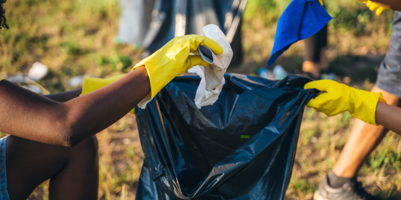 Group of volunteers cleaning up garbage outdoors