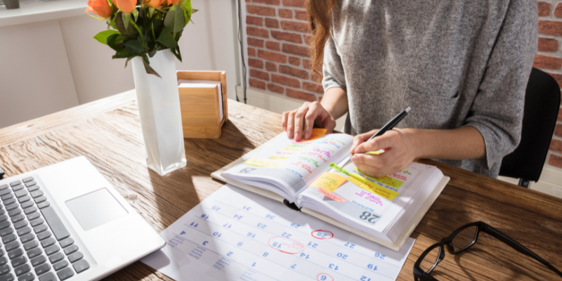 Woman writing in a planner at home office desk