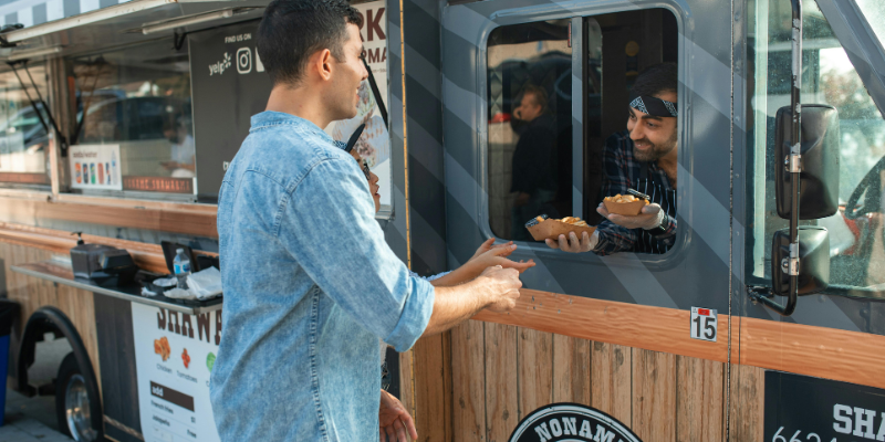 Man picking up food from a shawarma food truck
