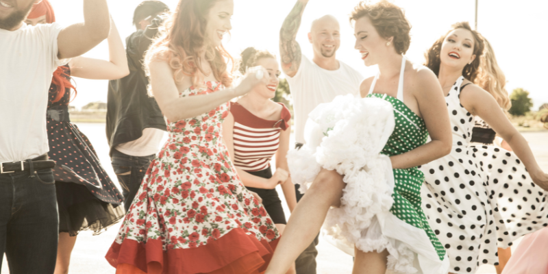 People in 1950s style clothing dancing outdoors