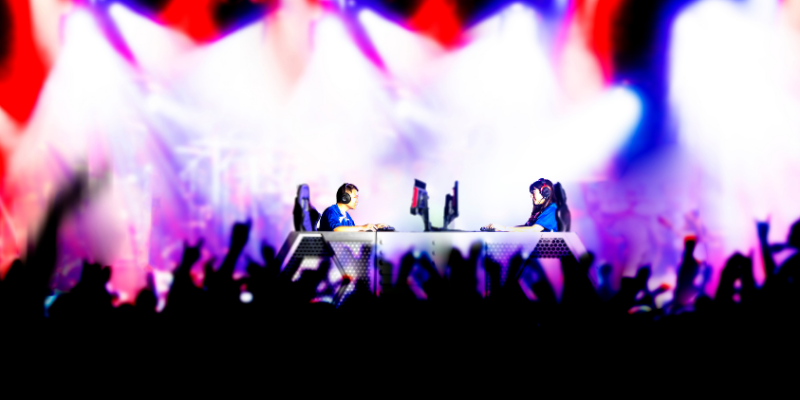 Young professionals playing eSports tournament on stage with a large audience