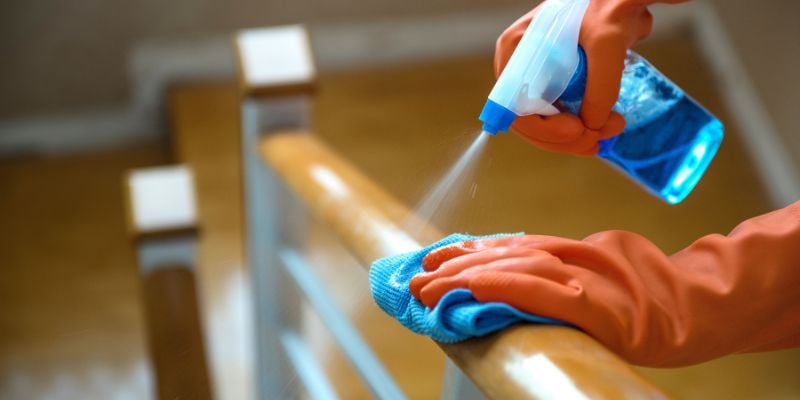 Gloves, spray bottle, and cleaning rag to clean off stair railing