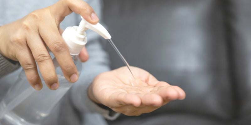 Woman pumping sanitizator on her hands