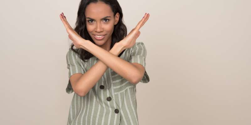 woman crossing arms in a "no" symbol in front of her chest