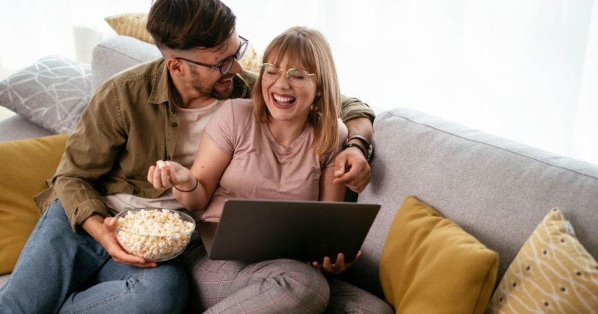 Happy couple watching event content on their laptop