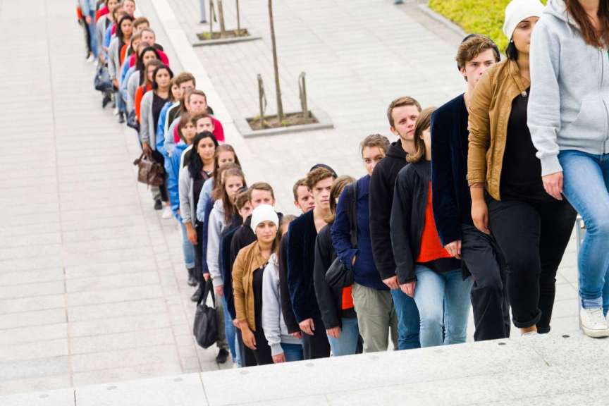 long line of people single-file winding up and down stairs