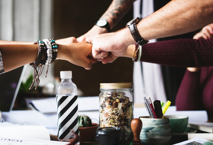 team of co-workers fist bumping