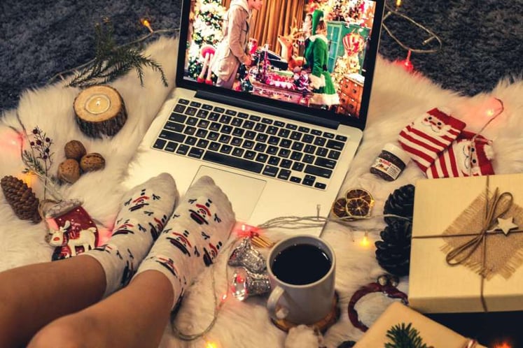 Guest enjoying a hybrid event from the comfort of her home with a coffee mug and a pair of socks