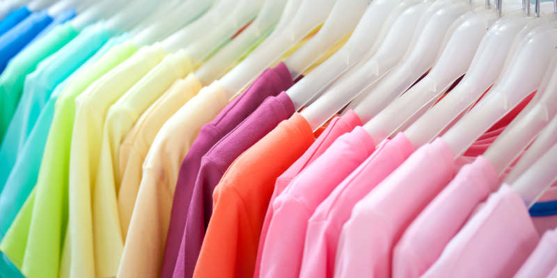 Selection of rainbow colored shirts on a rack