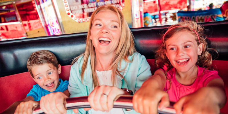 Woman with two children on an amusement park ride