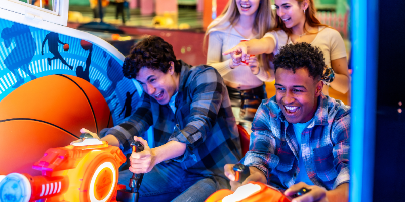 Young adults enjoying time together while playing arcade games