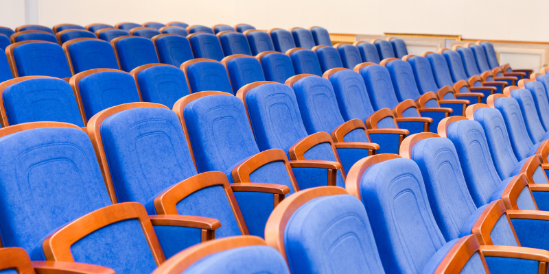 Conference hall with rows of empty blue chairs