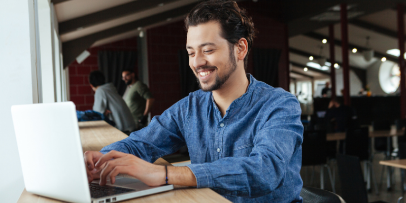 Happy man using laptop computer in an office