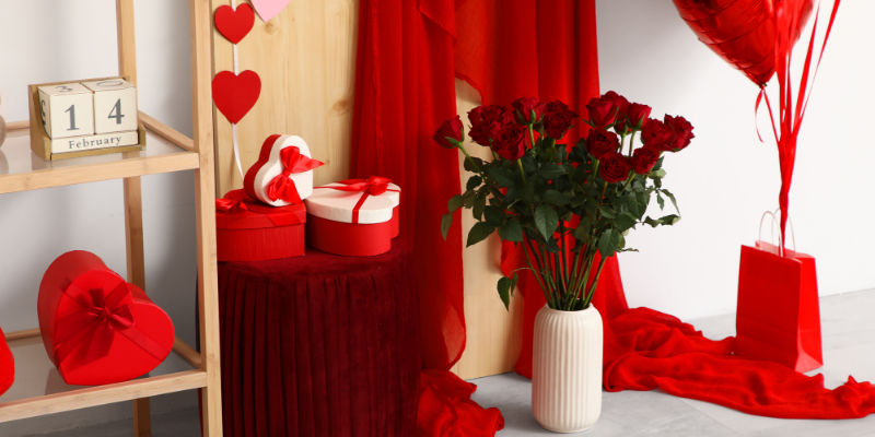 Interior of a festive room decorated for Valentine's Day with red roses, heart shapes boxes and balloons