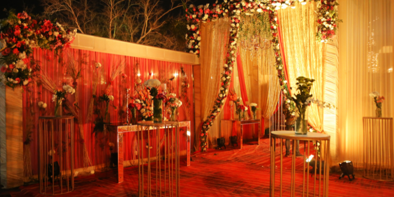 View of the entrance to an event venue with red and gold flowers surrounding it