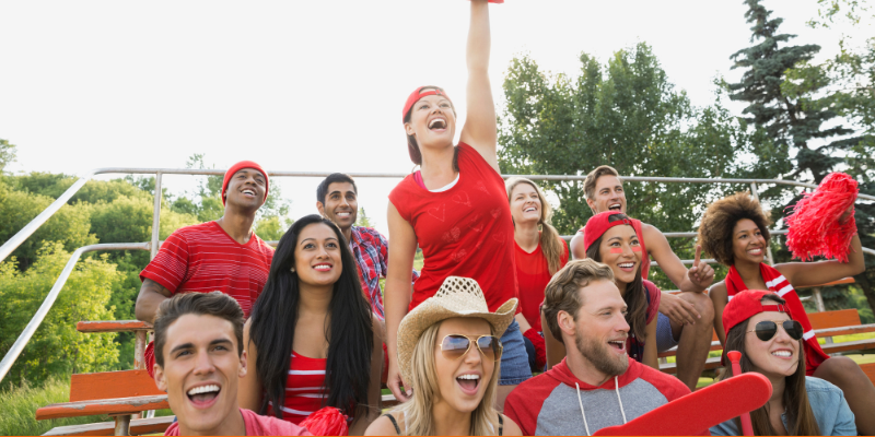 Friends cheering at a sporting event outside