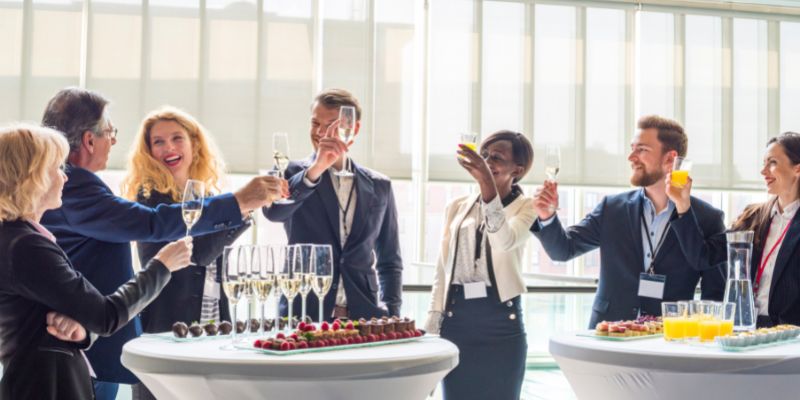 Colleagues at a business event standing and toasting champagne