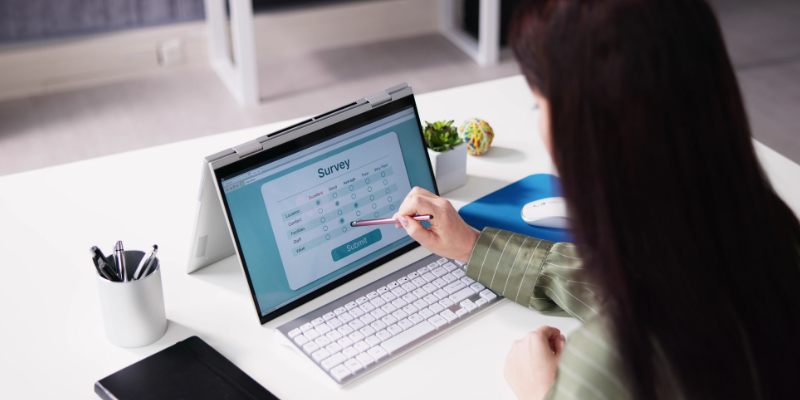 Woman in a modern office taking a survey on laptop computer